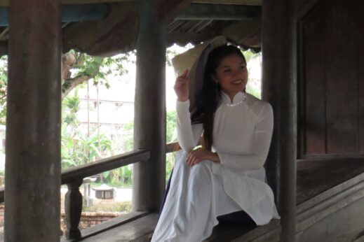 A girl wearing a traditional Ao Dai outfit on a bridge in the Hue countryside 