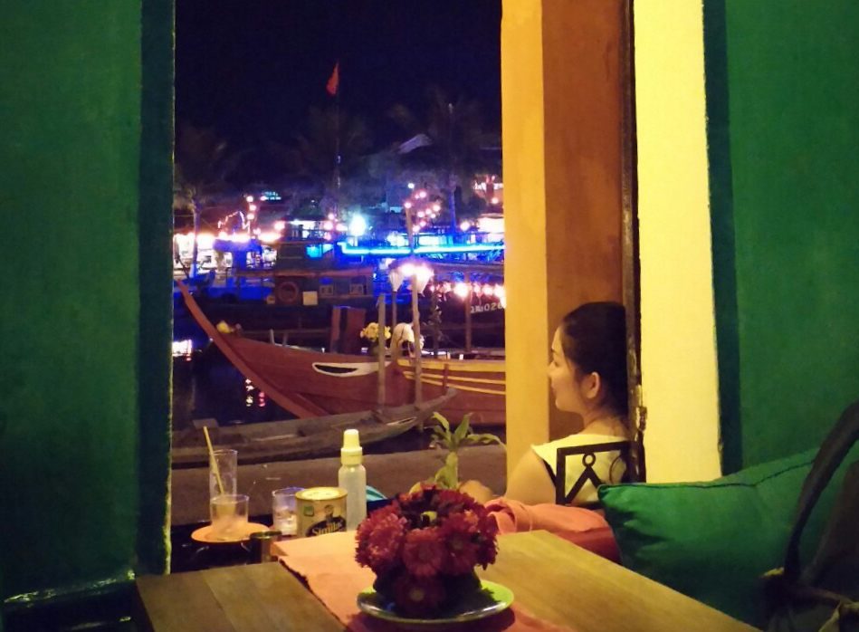 A lady looks out to the sea at night in Vietnam