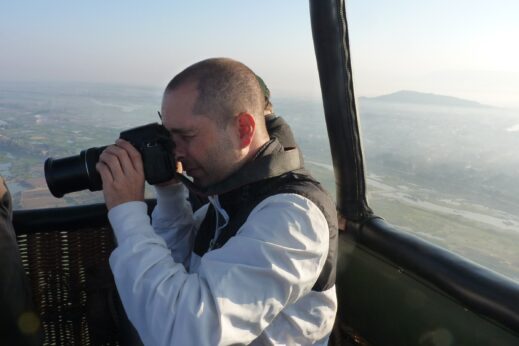 Man taking photograph in hot air balloon over Burma