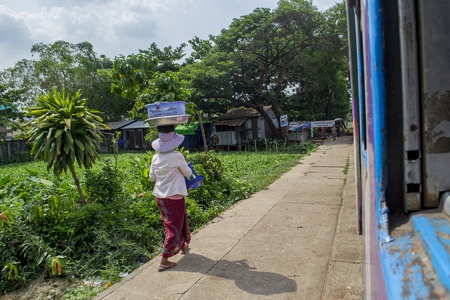 A lady carrying washing on her head outside Yangon's circle train, Burma (Myanmar)